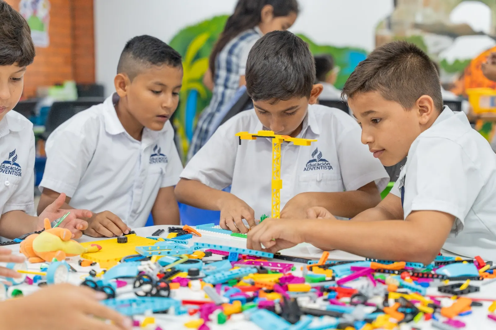 Tres niños construyen juntos una grúa de piezas