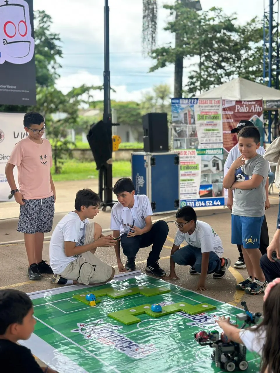 Jóvenes guían sus robots sobre una pista de competencia