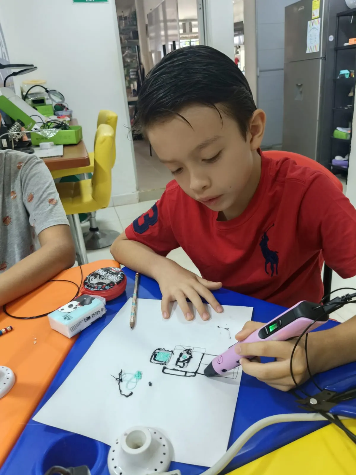 Niño dibuja en tres dimensiones con un lápiz 3D