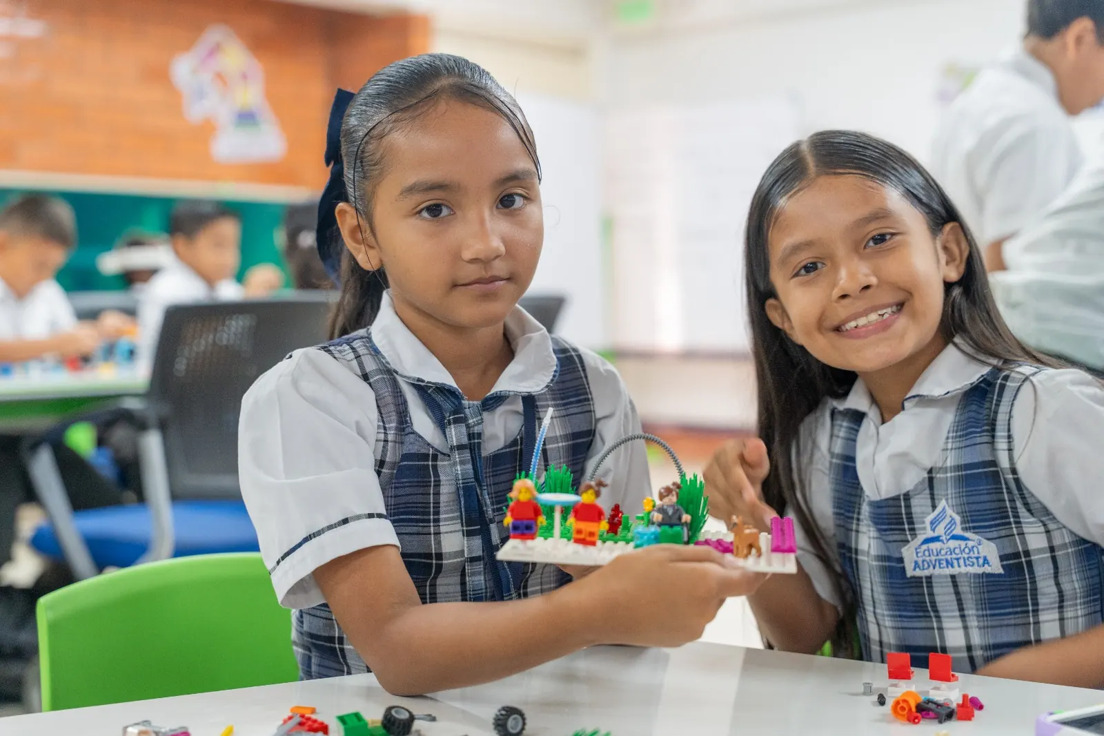 Dos niñas muestran el robot que construyeron